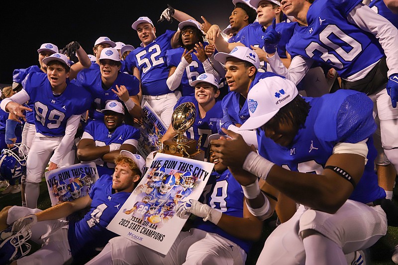 Staff photo by Olivia Ross / McCallie’s Carson Gentle (17) holds the TSSAA Division II-AAA state championship trophy as the Blue Tornado celebrate after beating Baylor in the BlueCross Bowl on Thursday night at Finley Stadium.