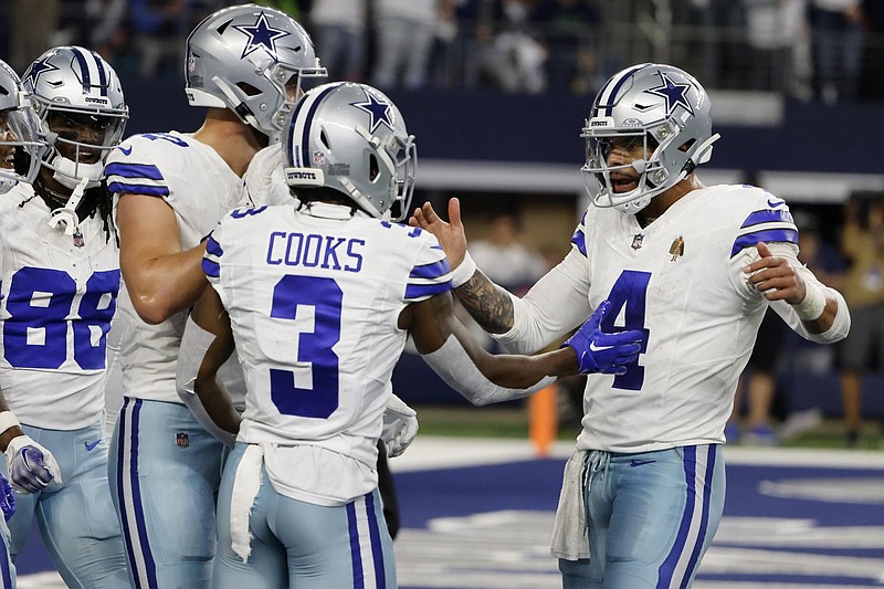 Quarterback Dak Prescott (right) celebrates with Brandin Cooks (3) and teammates after Cooks caught a touchdown pass during the Cowboys’ 41-35 victory over the Seattle Seahawks at AT&T Stadium in Arlington, Texas. More photos at arkansasonline.com/121dcss/.
(AP/Michael Ainsworth)