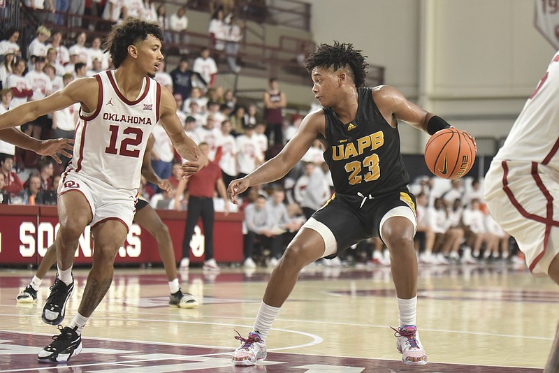 Lonnell Martin Jr. (23), a guard with the University of Arkansas at Pine Bluff, tries to push past Oklahoma guard Milos Uzan (12) during the second half in Norman, Okla., on Thursday, Nov. 30, 2023. (AP/Kyle Phillips)