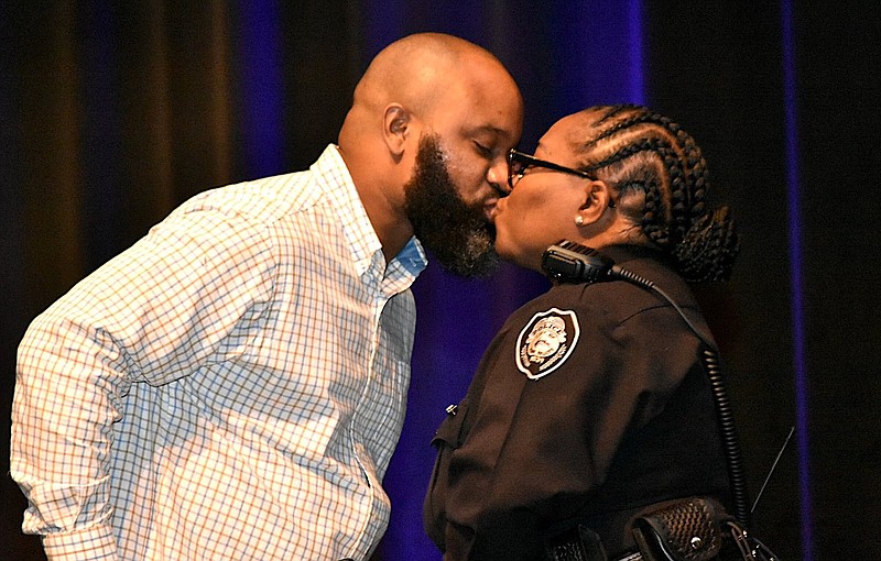 Newly promoted Pine Bluff Police Sgt. Helen Irby receives a kiss from her husband Brandon after receiving her sergeant's pin during a promotion ceremony Thursday at the Pine Bluff Convention Center. (Pine Bluff Commercial/I.C. Murrell)