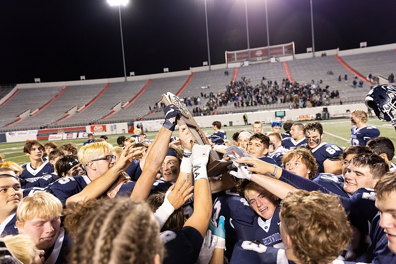 Greenwood players celebrate with the state championship trophy Friday night at War Memorial Stadium in Little Rock after the Bulldogs’ victory over Little Rock Christian in the Class 6A championship game. It was Greenwood’s 11th state title. More photos available
at arkansasonline.com/122class6afbchamp/.
(Arkansas Democrat-Gazette/Justin Cunningham)