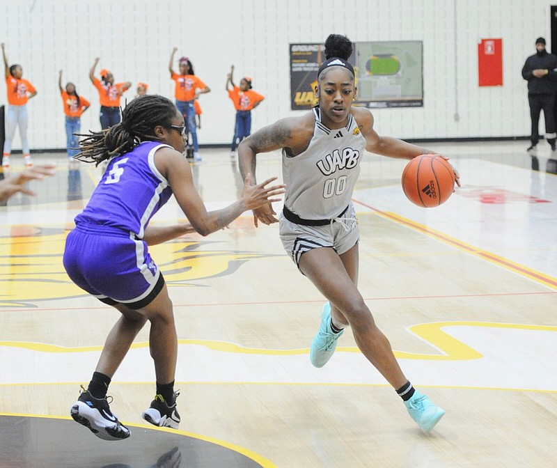 UAPB guard Zaay Green drives the ball against Arkansas Baptist guard Cebbie Peacock during Friday's basketball game at H.O. Clemmons Arena. Green finished with her second triple-double of the season. (Special to the Commercial/William Harvey)