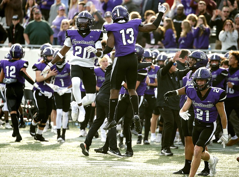 Fayetteville defensive back Xzavier Burns (20) celebrates with teammate Isaiah Taylor (13) after a fourth down stop in the fourth quarter of the Purple Dogs’ 22-16 win in the Class 7A state championship game on Saturday, Dec. 2, 2023, at War Memorial Stadium in Little Rock. .More photos at www.arkansasonline.com/123state7a23/.(Arkansas Democrat-Gazette/Thomas Metthe)