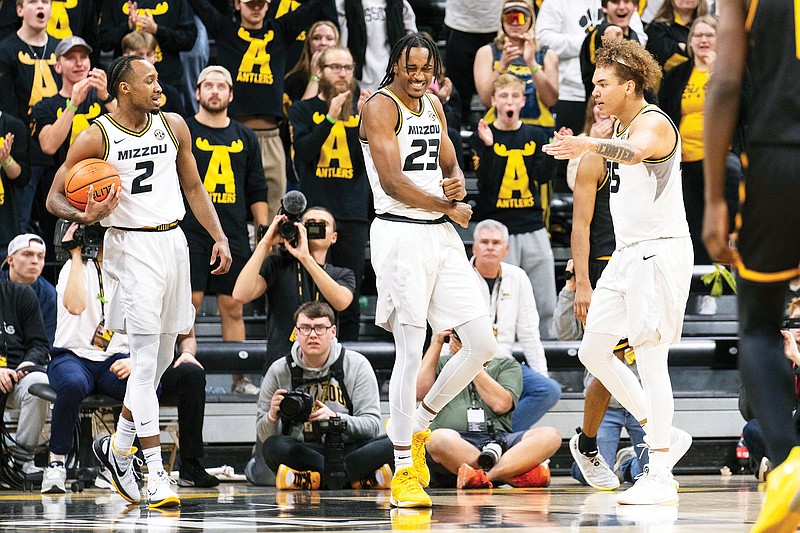 Aidan Shaw (center) celebrates with Missouri teammates Tamar Bates (left) and Noah Carter after a basket during the second half of Sunday afternoon’s game at Mizzou Arena in Columbia. (Associated Press)