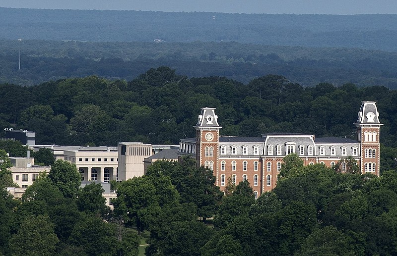 The two towers of Old Main are visible in the foreground on the campus of the University of Arkansas in Fayetteville in this June 18, 2023 file photo. Old Main houses classrooms and the offices of the J. William Fulbright College of Arts and Sciences. Buildings partly visible in the background include Vol Walker Hall and, behind that, the David W. Mullins Library. (NWA Democrat-Gazette/J.T. Wampler)