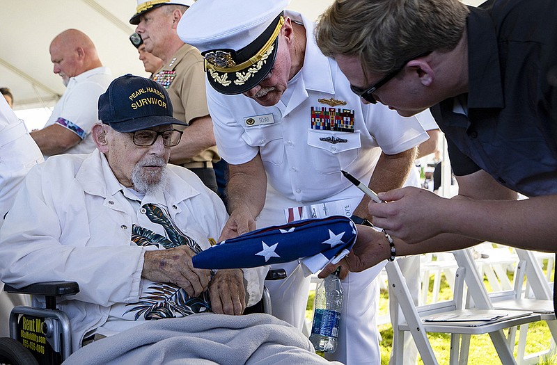 An attendee asks Pearl Harbor survivor Ira “Ike” Schab, 103, to sign a U.S. flag Thursday during the 82nd Pearl Harbor Remembrance Day ceremony at Pearl Harbor in Honolulu, Hawaii. More photos at arkansasonline.com/128pearlharbor/.
(AP/Mengshin Lin)