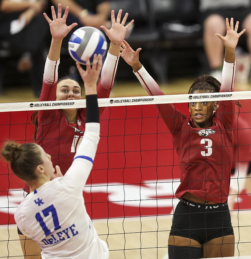 Arkansas’ Maggie Cartwright (11) and Sania Petties (3) go up to block against Kentucky’s Brooklyn DeLeye (17) during the third set of their regional semifinal match Thursday in Lincoln, Neb. The Razorbacks beat the Wildcats in five sets to set up a regional final matchup with the top-seeded Nebraska Cornhuskers at 5 p.m. Central today.
(AP/Omaha World-Herald/Nikos Frazier)