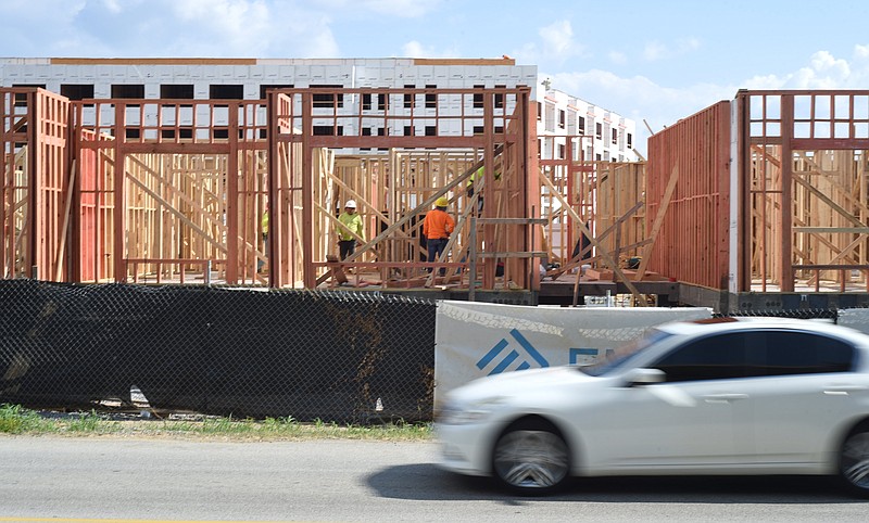 Staff photo by Matt Hamilton / Workers construct apartment buildings as traffic moves along Manufacturers Road on Friday, Sept. 8, 2023.