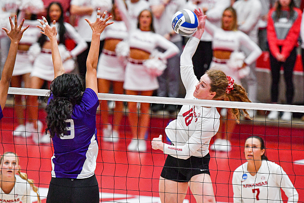 Arkansas outside hitter Jill Gillen (10) spikes as Stephen F. Austin middle blocker Izabella Ortiz (9) attempts to block, Friday, Dec. 1, 2023, during the second set of the Razorbacks’ 3-0 win (25-8, 25-17, 25-23) win over the Lady Jacks in first round of the NCAA Div. I Women’s Volleyball Championship at Barnhill Arena in Fayetteville.