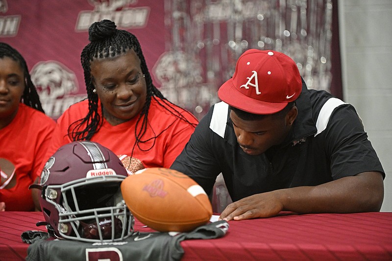 Benton running back Braylen Russell (right) signs a national letter of intent to play at Arkansas as his mother Shenikka Russell looks on Wednesday at the Benton Athletic Complex.
(Arkansas Democrat-Gazette/Staci Vandagriff)