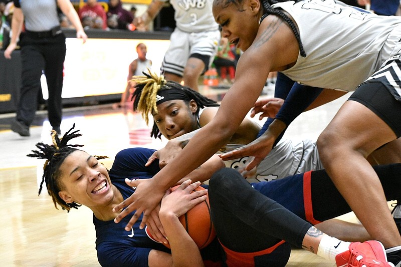 Snudda Collins of Ole Miss dives on a loose ball at H.O. Clemmons Arena in Pine Bluff during the first half on Thursday, Dec. 21, 2023 as Kourtney Rittenberry (4) and Coriah Beck (15), both of the University of Arkansas at Pine Bluff, try to tie it up. (Pine Bluff Commercial/I.C. Murrell)
