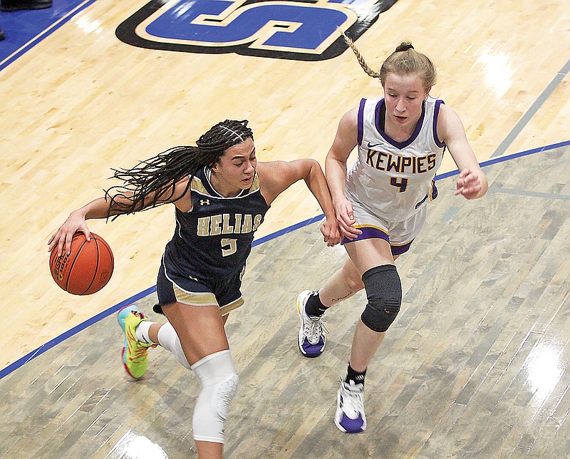 Claire Galbraith of Helias dribbles the ball along the baseline against Hickman's Lucy Elfrink during last season's semifinal game of the Jefferson Bank Holiday Hoops Classic at Capital City High School. (Greg Jackson/News Tribune)