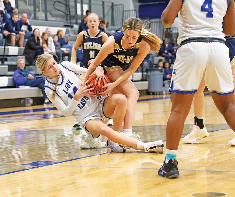 Capital City's Aslyn Marshall and Claire Morris of Helias battle for a loose ball Thursday in the Jefferson Bank Holiday Hoops Classic at Capital City High School. (Jason Strickland/News Tribune)