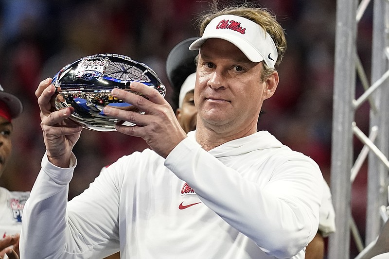 Mississippi head coach Lane Kiffin holds part of the championship trophy after the Peach Bowl NCAA college football game between Penn State and Mississippi, Saturday, Dec. 30, 2023, in Atlanta. Mississippi won 38-25. (AP Photo/Brynn Anderson)
