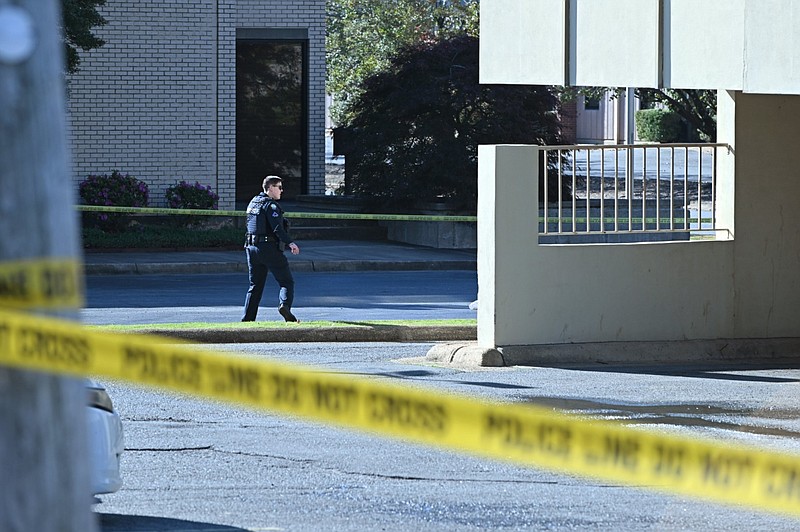 A Little Rock Police Department officer walks around the scene of a shooting at the West Park Executive Building, 7101 W. 12th St., in Little Rock in this Nov. 19, 2023 file photo. Investigators were studying the scene one day after police found Marcus Marbley, 17, of Little Rock shot dead in a vehicle outside the office building. (Arkansas Democrat-Gazette/Staci Vandagriff)