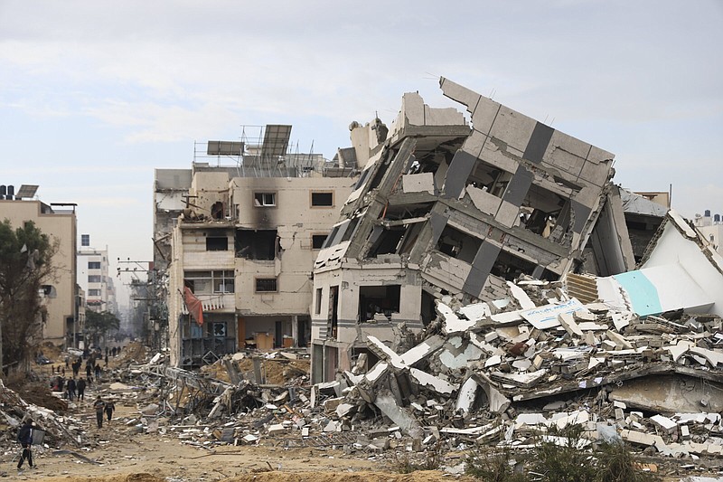 Palestinians walk past buildings destroyed in the Israeli bombardment of the Gaza Strip in Gaza City on Wednesday. More photos at arkansasonline.com/gazaweek13/.
(AP/Mohammed Hajjar)