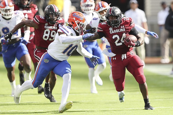 South Carolina running back Mario Anderson (24) tries to stiff arm Florida safety Miguel Mitchell (10) during the first half of an NCAA college football game on Saturday, Oct. 14, 2023, in Columbia, S.C. (AP Photo/Artie Walker Jr.)