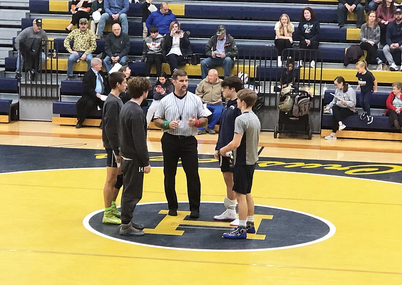 Team captains from Helias (right) and Battle meet with the official prior to the start of Thursday night's Central Missouri Activities Conference boys wrestling dual at Rackers Fieldhouse. (Tom Rackers/News Tribune)