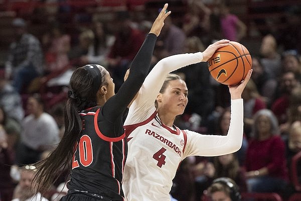 Arkansas’ Saylor Poffenbarger (4) looks for help under pressure from Georgia’s Jordan Cole on Sunday Jan. 7, 2024, at Bud Walton Arena in Fayetteville.