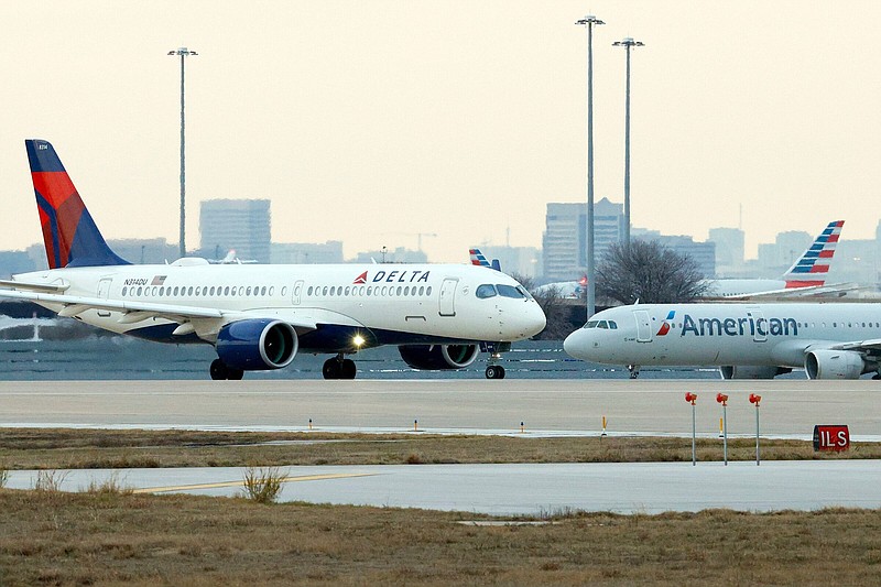 A Delta Air Lines aircraft and an American Airlines aircraft wait to take off at Dallas/Fort Worth International Airport on Jan. 2.
(TNS/The Dallas Morning News/Elías Valverde II)