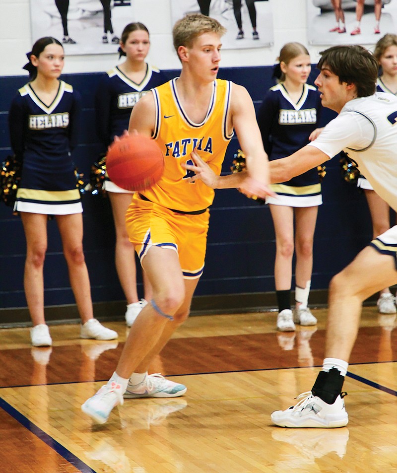 Levi Robinson of Fatima dribbles against the defense of Kase Winegar of Helias during Thursday night’s game at Rackers Fieldhouse. (Alexa Pfeiffer/News Tribune)