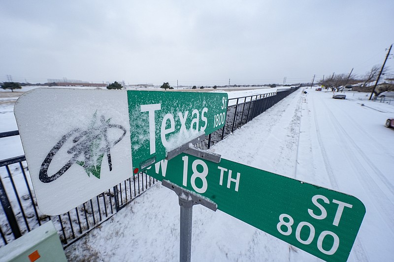 Snow covers the sign for Texas Street during a winter storm, Monday, Jan. 15, 2024, in Grand Prairie, Texas. (AP Photo/Julio Cortez)