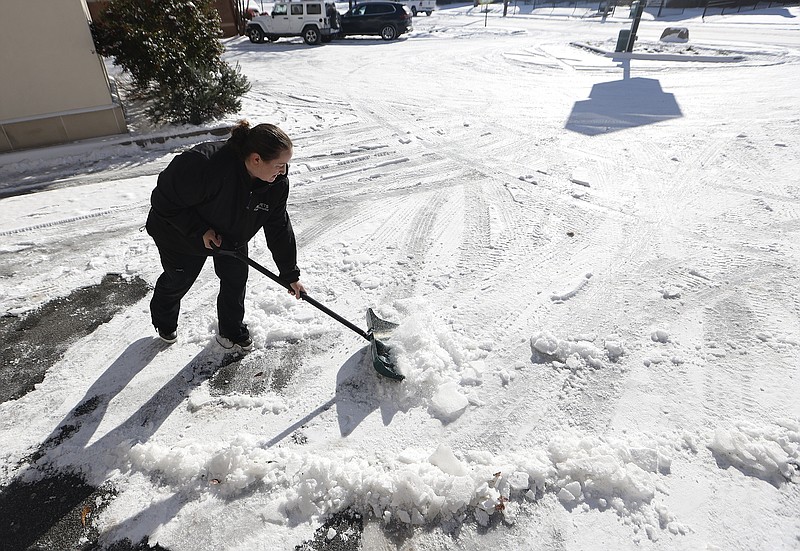 Adrienne Phillips, manager of AllPets Animal Hospital, shovels snow from the parking lot of the facility on Tuesday, Jan. 16, 2024, in Little Rock. .More photos at www.arkansasonline.com/117snow/.(Arkansas Democrat-Gazette/Thomas Metthe)
