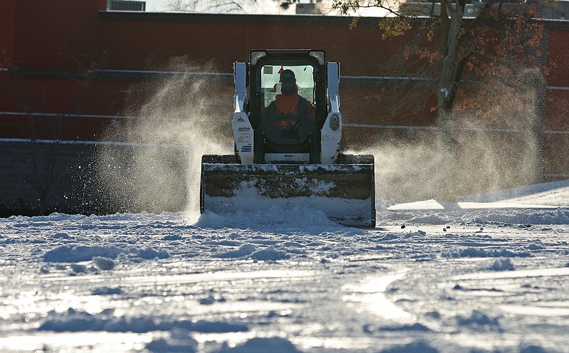 A skid steer loader is used to remove snow from a parking lot at McCain Mall in North Little Rock on Tuesday, Jan. 16, 2024. (Arkansas Democrat-Gazette/Colin Murphey)