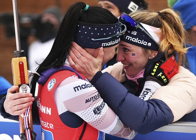 FILE - Joanne Reid, left, of United States, and compatriot Deedra Irwin embrace at the finish line during the women's 4 x 6 km relay race at the biathlon World Cup in Anterselva, Italy, Jan. 22, 2022. The United States Biathlon national champion was sexually harassed and abused for years by a ski-wax technician while racing on the sport's elite World Cup circuit, investigators found. When the two-time Olympian complained, Reid said she was told his behavior was just part of the male European culture. (AP Photo/Matthias Schrader)