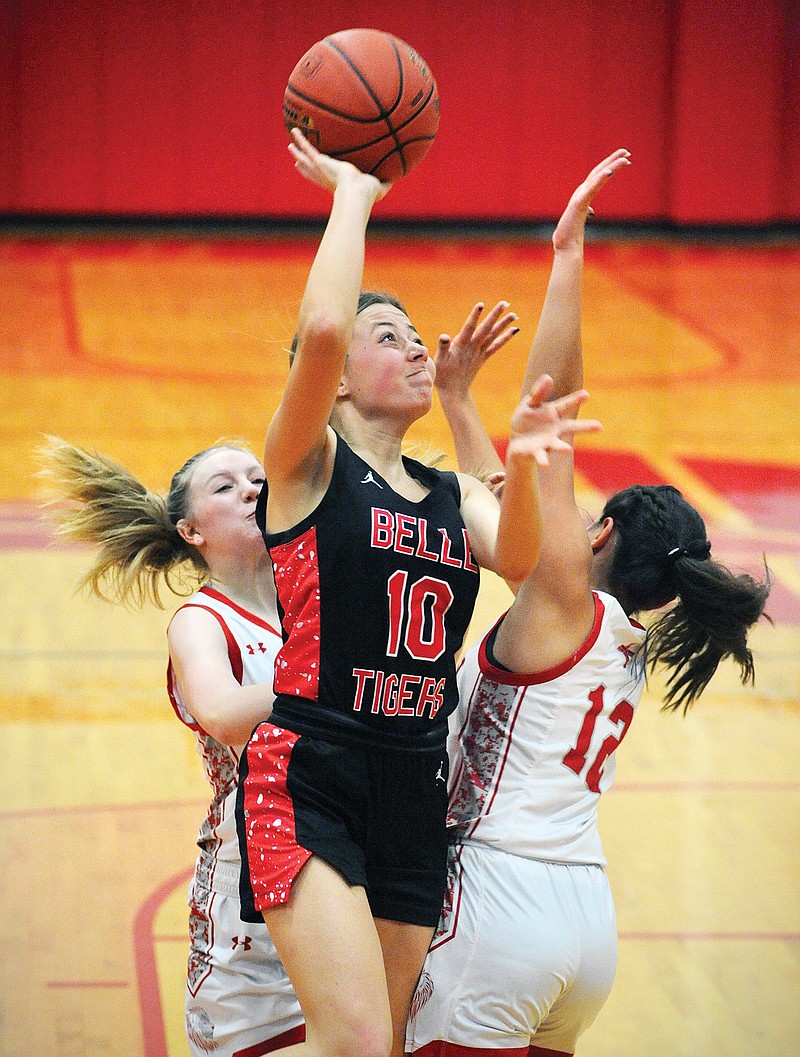 Belle's Natalie Gehlert puts up a shot between Calvary Lutheran's Mahaila Brunner (12) and Leah Thompson during Monday night’s game at Calvary Lutheran High School. (Shaun Zimmerman/News Tribune)