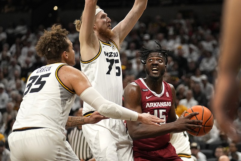 Arkansas' Makhi Mitchell (15) heads to the basket as Missouri's Connor Vanover (75) and Noah Carter (35) defend during the first half of an NCAA college basketball game Wednesday, Jan. 31, 2024, in Columbia, Mo. (AP Photo/Jeff Roberson)