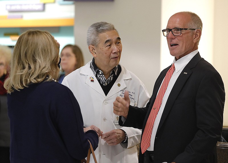 Chris Fowler (right) of Jonesboro talks with Dr. James Suen (center) and Suen’s wife, Karen (left), after an announcement that Fowler had donated $5 million to UAMS’s Winthrop Rockefeller Cancer Center on Thursday, Feb. 1, 2023, in Little Rock. Dr. Suen was Fowler’s cancer doctor when he was undergoing treatment at the center. .(Arkansas Democrat-Gazette/Thomas Metthe)