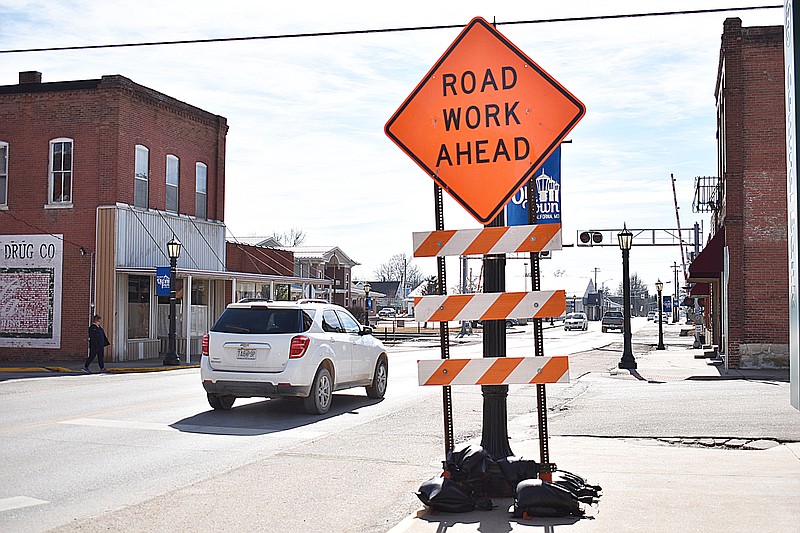 Democrat photo/Garrett Fuller — A "road work ahead" sign is seen Monday near South Oak and Smith streets as S&A Equipment & Builders, LLC, of Fulton, prepare to begin work on accessibility improvements to the South Oak Street sidewalk between Buchanan Street and Parkway Drive. The project is one of more than a dozen accessibility improvements around Central Missouri that is being completed this year for the Missouri Department of Transportation.