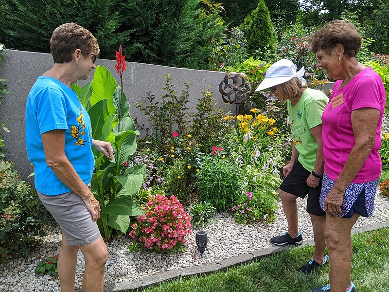 News Tribune file photo: Sue Kauffman, far right, talked about a plant in her garden with members of the Bittersweet Garden Club before visitors arrived on garden tours Sunday, June 26, 2022. For 2024, the club will hold a garden party as its main fundraiser, with the tours to return the following year.