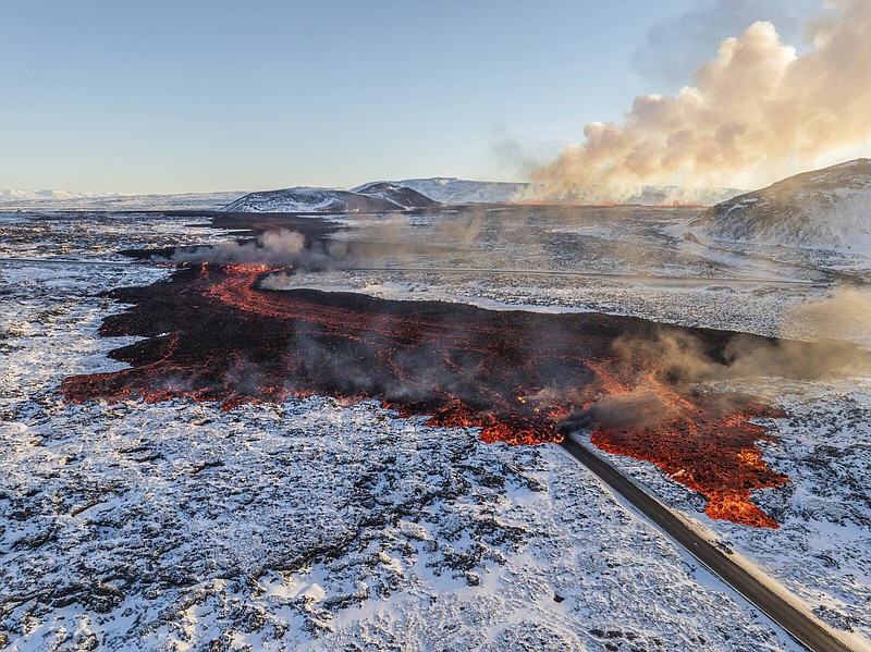 Lava crosses the main road to Grindavík and flows onto the road leading to the Blue Lagoon in Grindavík, Iceland, on Thursday.
(AP/Marco Di Marco)
