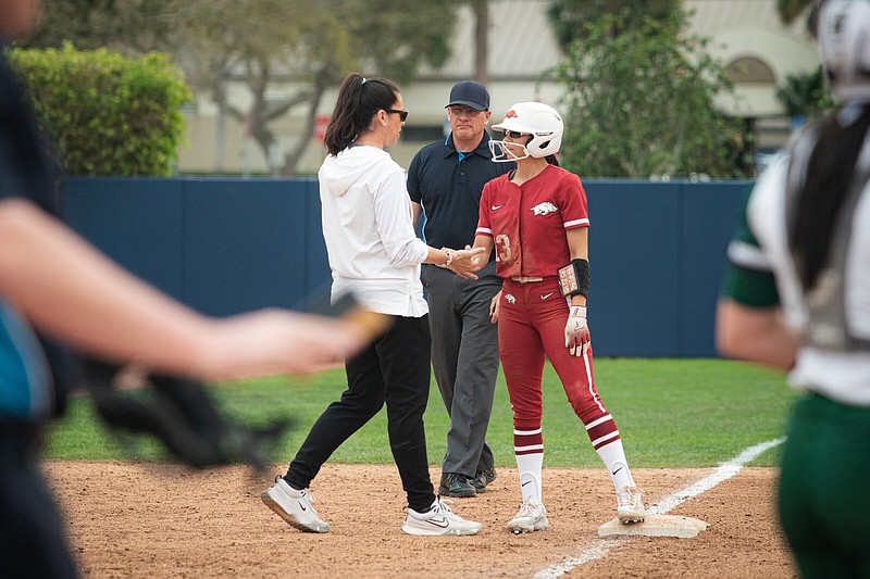 Arkansas center fielder Reagan Johnson (right) speaks to Coach Courtney Deifel at third base Friday during the Razorbacks’ 7-3 victory over the Ohio Bobcats at the Paradise Classic in Boca Raton, Fla. Johnson went 4 for 4 with 2 runs scored in the victory.
(Arkansas Athletics/Meaghan Frazier)
