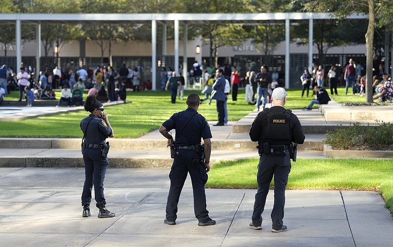 Houston police officers watch over displaced churchgoers outside Lakewood Church, after a reported shooting during a Spanish church service on Sunday.
(AP/Houston Chronicle/Karen Warren)