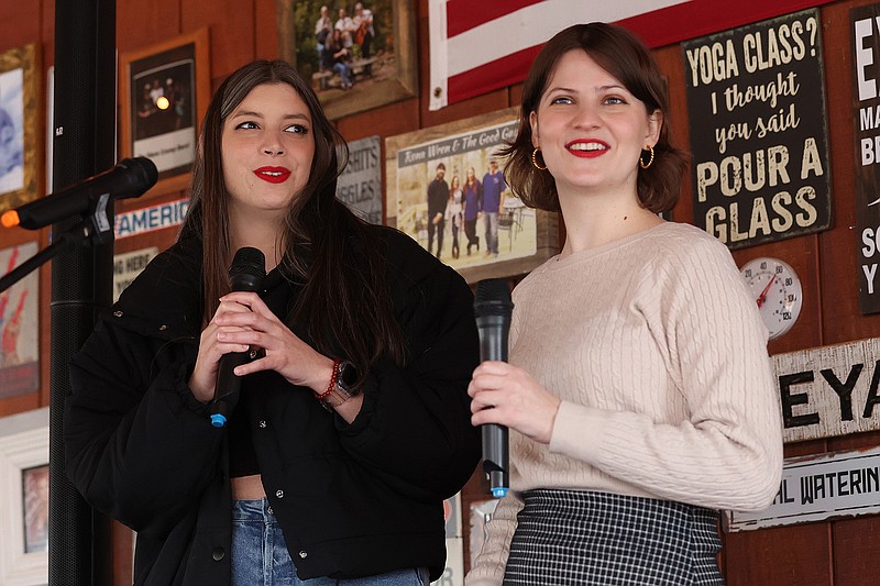 Julie Pollard (left) and Naty Doris sing a Taylor Swift karaoke song during a Taylor Swift-themed Super Bowl watch party at the River Bottom Winery near Roland on Sunday. (Arkansas Democrat-Gazette/Colin Murphey)