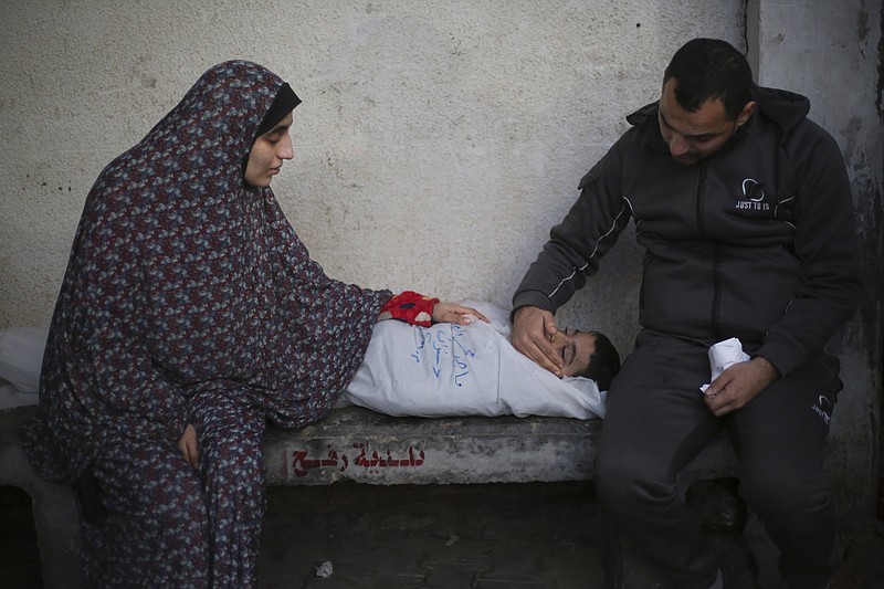 Palestinians mourn a child killed in the Israeli bombardment of the Gaza Strip at a hospital morgue in Rafah, Monday, Feb. 12, 2024. (AP Photo/Hatem Ali)
