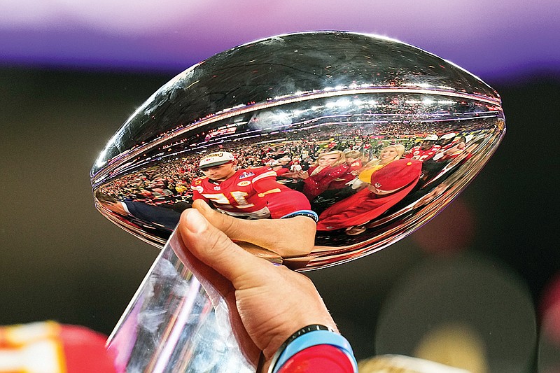 Chiefs quarterback Patrick Mahomes is reflected in the Vince Lombardi Trophy after Sunday night’s overtime win against the 49ers in Super Bowl 58 in Las Vegas. (Associated Press)