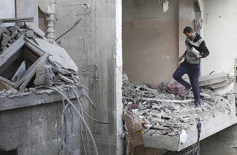 A Palestinian collects books Wednesday after an Israeli strike on a residential building in Rafah, Gaza Strip. More photos at arkansasonline.com/gazaweek20/.
(AP/Hatem Ali)