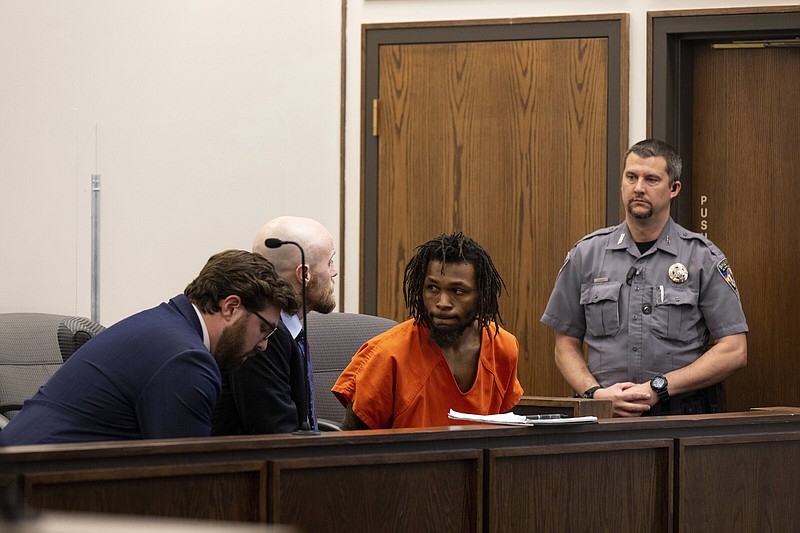 Nicholas Jordan (center right) speaks with his legal counsel during his first appearance at the El Paso County Combined Courts in Colorado Springs Colo., on Friday.
(AP/The Gazette/Parker Seibold)