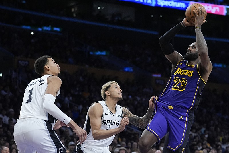 Los Angeles Lakers forward LeBron James (23) shoots over San Antonio Spurs forward Jeremy Sochan, center, and center Victor Wembanyama (1) during the second half of an NBA basketball game Friday, Feb. 23, 2024, in Los Angeles. (AP Photo/Marcio Jose Sanchez)