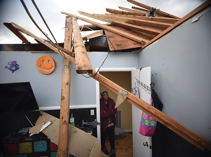 Staff photo by Tim Barber/ Tina Bonner Brooks looks into her guest bedroom Monday morning, Apr. 13, 2020, where her grandson Zenarion Taylor, 5, was sleeping when a tornado ripped the roof away. A ceiling fan is seen, top right, that used to be in the room.