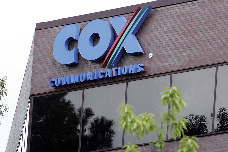 One of the buildings of the Cox Communications campus is surrounded by foliage in Atlanta on, Aug. 2, 2004. (AP Photo/Ric Feld, File)