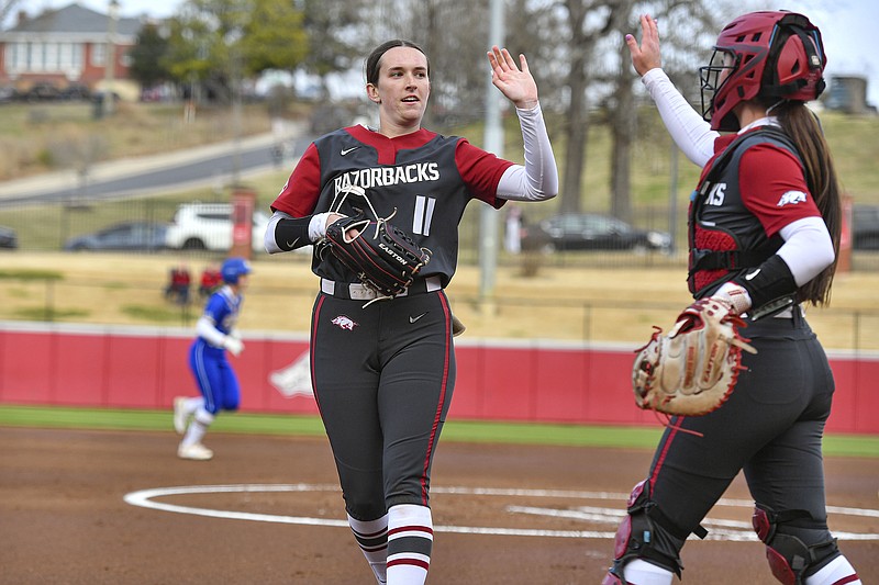 Arkansas starting pitcher Robyn Herron (11) high-fives catcher Kennedy Miller (17), Thursday, Feb. 29, 2024, during the first inning of the Razorbacks’ 4-3 win over South Dakota State in the opening game of the Wooo Pig Classic at Bogle Park in Fayetteville. Visit nwaonline.com/photo for today's photo gallery..(NWA Democrat-Gazette/Hank Layton)
