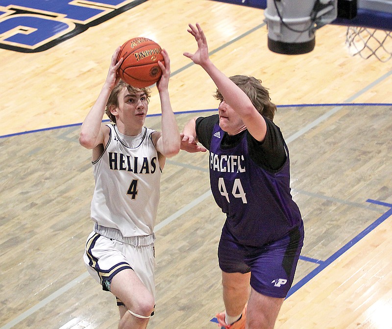 Beau Blanton of Helias drives to the basket for a layup against Pacific’s Alex Gehm during Thursday night’s first-round game in the Class 5 District 5 Tournament at Capital City High School. (Greg Jackson/News Tribune)