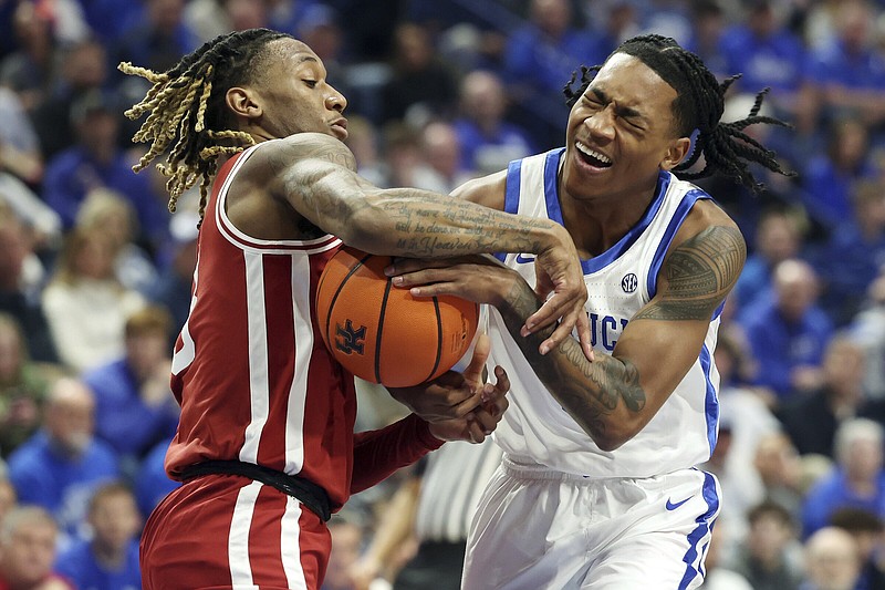 Kentucky's Rob Dillingham, right, collides with Arkansas' El Ellis, left, during the first half of an NCAA college basketball game Saturday, March 2, 2024, in Lexington, Ky. (AP Photo/James Crisp)