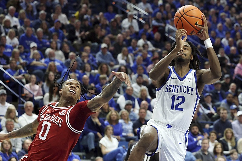 Kentucky's Antonio Reeves (12) shoots while defended by Arkansas' Khalif Battle (0) during the second half of an NCAA college basketball game Saturday, March 2, 2024, in Lexington, Ky. (AP Photo/James Crisp)