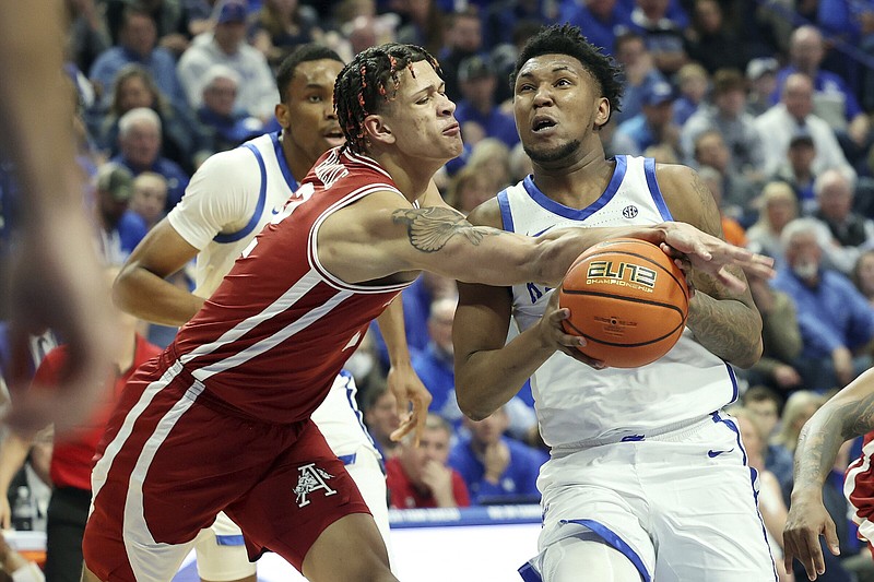 Kentucky's Justin Edwards, right, is fouled by Arkansas' Trevon Brazile, left, during the first half of an NCAA college basketball game Saturday, March 2, 2024, in Lexington, Ky. (AP Photo/James Crisp)